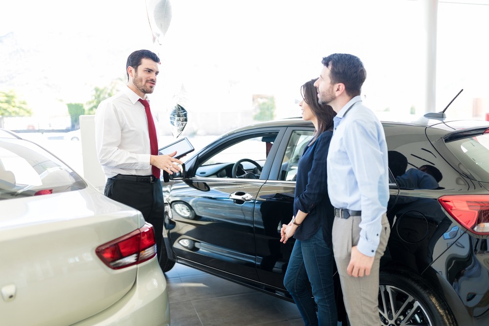 Couple Listening To Car Salesman With Trust