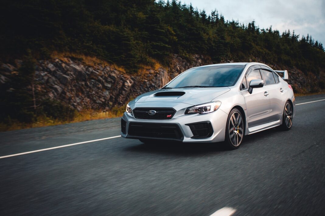 silver-subaru-car-driving-down-the-road