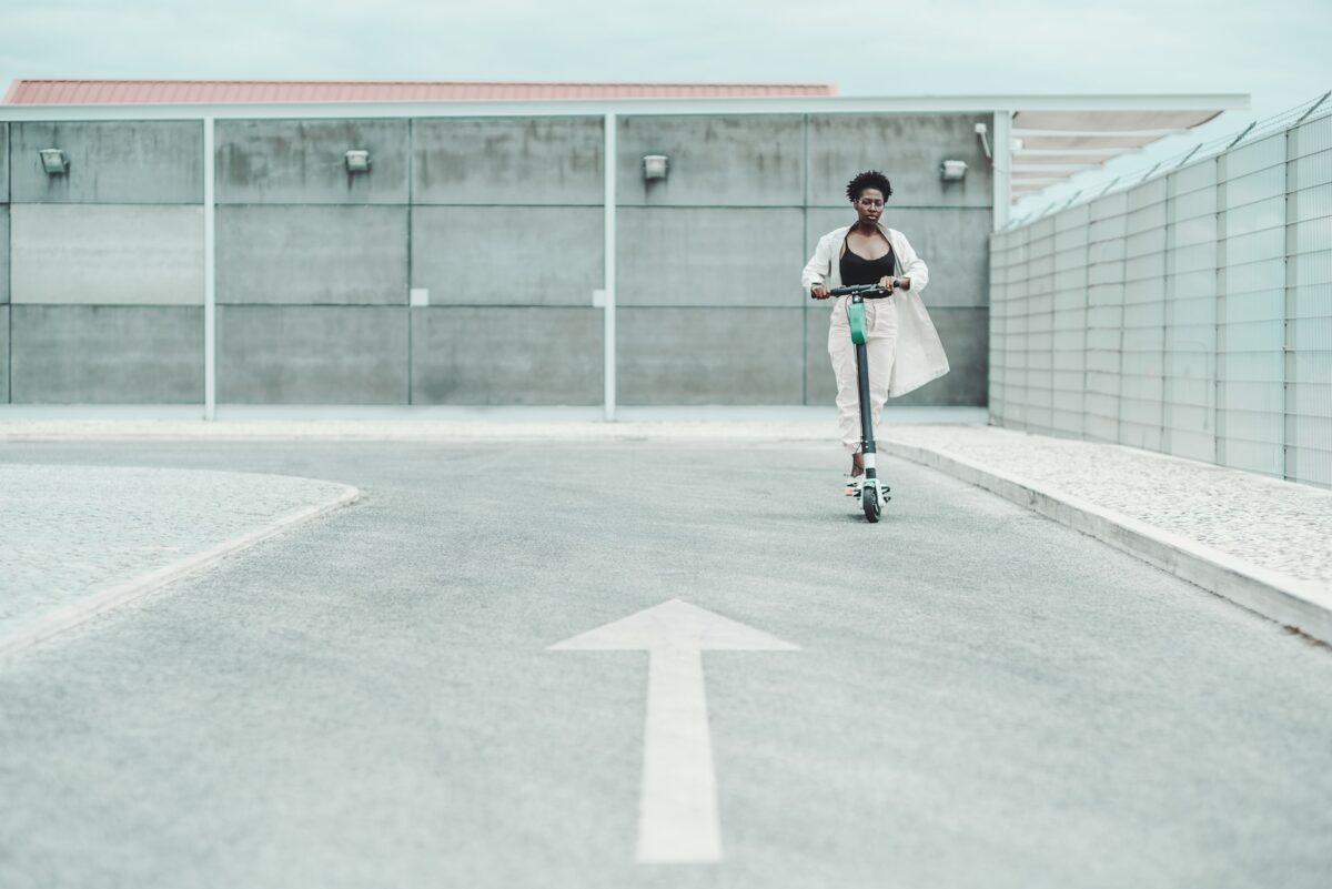 a woman rides an electric scooter in an empty parking lot