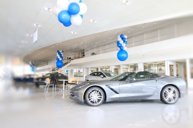 a-silver-sports-car-in-a-showroom-with-blue-and-white-balloons